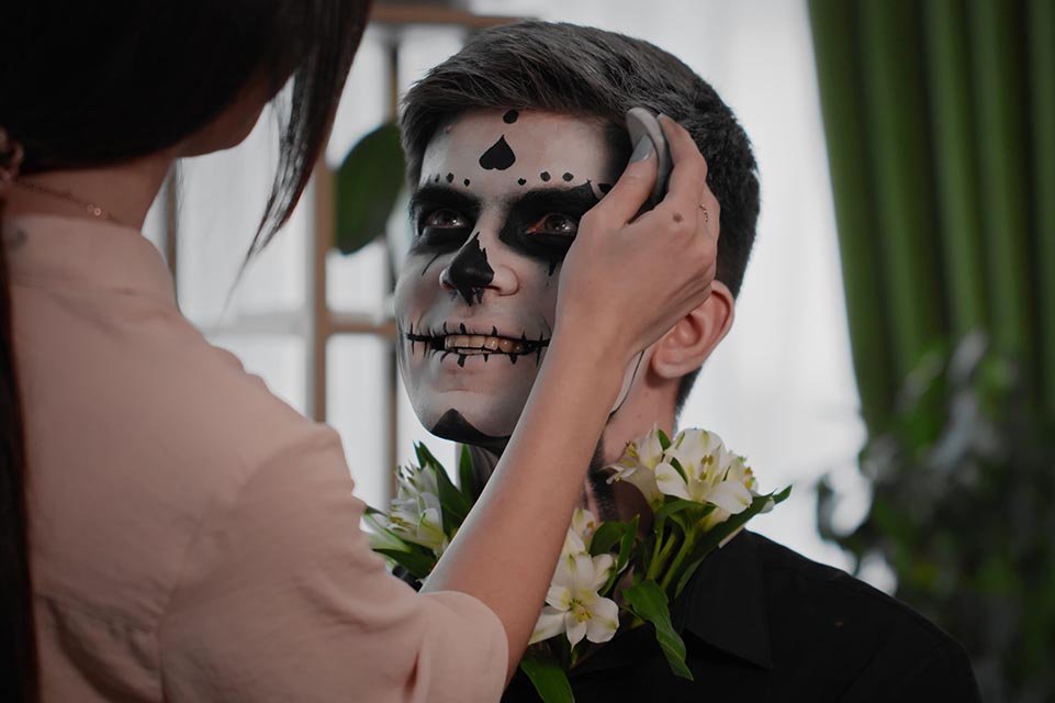 A young man is preparing makeup for Halloween. Create a Halloween look